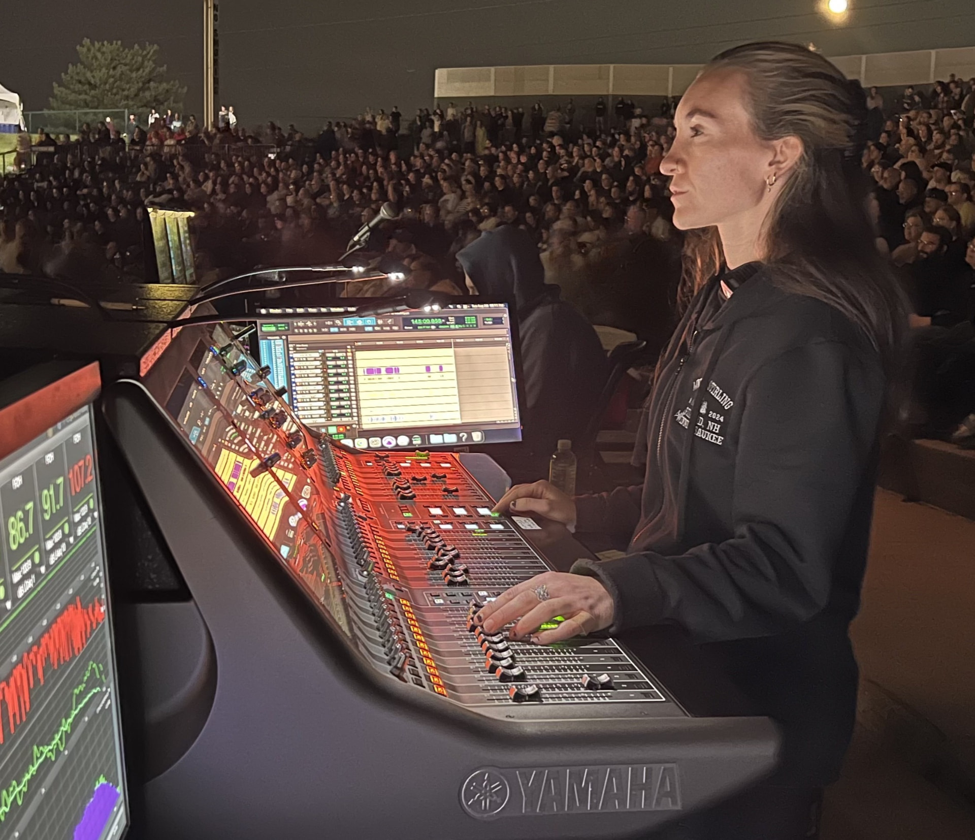 Ingeniero de audio operando una consola FOH en concierto